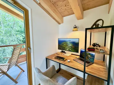 a computer on a desk in a room with a window at Les cimes de l alpage - Duplex luxe 130 m2 au pied des pistes in Combloux