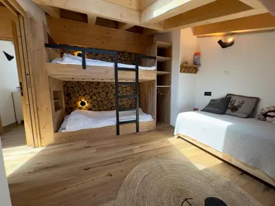 a bedroom with two bunk beds and a rug at Les cimes de l alpage - Duplex luxe 130 m2 au pied des pistes in Combloux