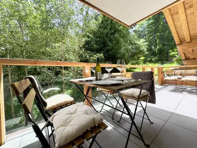 a screened in porch with a table and chairs at Les cimes de l alpage - Duplex luxe 130 m2 au pied des pistes in Combloux