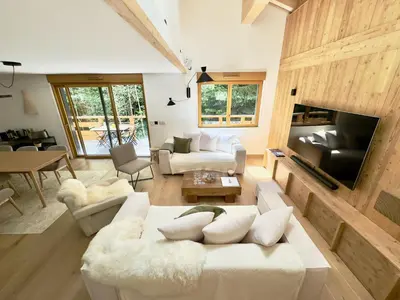 a living room with a white couch and a tv at Les cimes de l alpage - Duplex luxe 130 m2 au pied des pistes in Combloux
