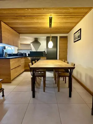a large kitchen with a wooden table and chairs at Marmotte Mountain Pic Vert in Chamonix-Mont-Blanc
