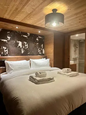 a bedroom with a large bed with towels on it at Marmotte Mountain Pic Vert in Chamonix-Mont-Blanc