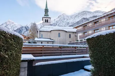a church with a steeple with snow on it at Delice - City center Les Houches & Free Parking - By Cozee Rentals in Les Houches