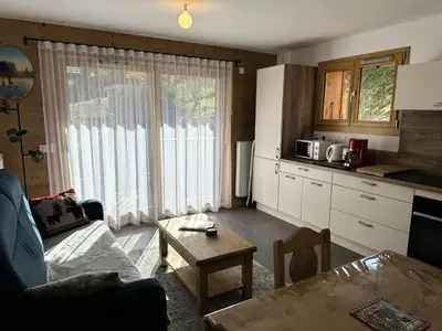a kitchen and living room with a couch and a table at Chalet Flore - CHALET FLORE MAE-6641 in Combloux