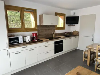 a kitchen with white cabinets and a counter top at Chalet Flore - CHALET FLORE MAE-6641 in Combloux