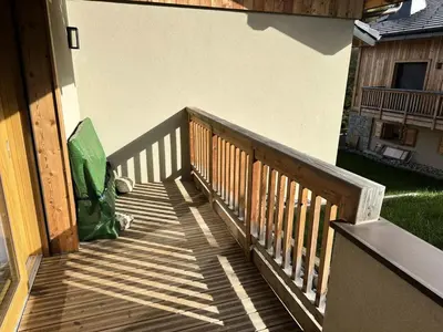 a wooden staircase with a green bag on a porch at Chalet Flore - CHALET FLORE MAE-6641 in Combloux