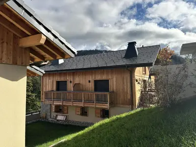a wooden house with a balcony and a roof at Chalet Flore - CHALET FLORE MAE-6641 in Combloux