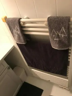 two towels are hanging on a shelf in a bathroom at STUDIO POINTE DES ARAVIS 4 PERS HTE-SAVOIE in Saint-Gervais-les-Bains