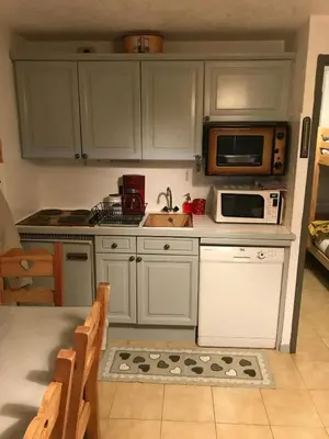 a kitchen with white cabinets and a sink and a microwave at STUDIO POINTE DES ARAVIS 4 PERS HTE-SAVOIE in Saint-Gervais-les-Bains