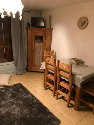 a dining room with a table and chairs and a television at STUDIO POINTE DES ARAVIS 4 PERS HTE-SAVOIE in Saint-Gervais-les-Bains