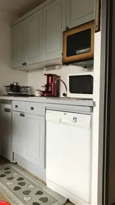 a kitchen with white cabinets and a dishwasher at STUDIO POINTE DES ARAVIS 4 PERS HTE-SAVOIE in Saint-Gervais-les-Bains