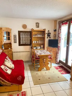 a living room with a table and a chair at Studio in Arâches-la-Frasse
