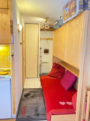 a small room with a red bed in a kitchen at Studio in Arâches-la-Frasse