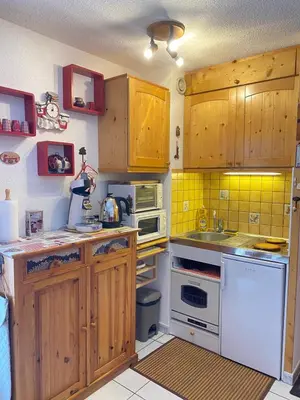 a kitchen with wooden cabinets and white appliances at Studio in Arâches-la-Frasse