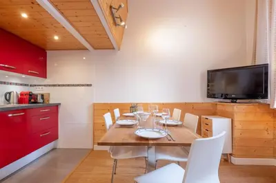 a kitchen and living room with a table and chairs at Ancolie - Apartment Free parking close to ski lift - By Cozee Rentals in Chamonix-Mont-Blanc