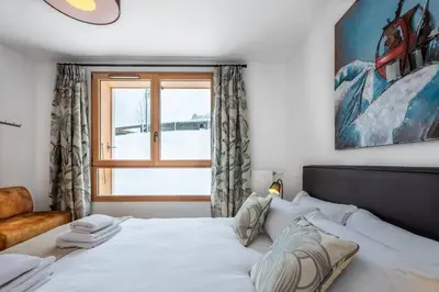 a bedroom with a white bed with a window at Le Freney - New Apartment in Town Center & Free parking - By Cozee Rentals in Les Houches