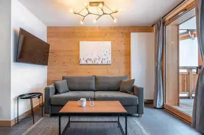 a living room with a couch and a table at Le Freney - New Apartment in Town Center & Free parking - By Cozee Rentals in Les Houches