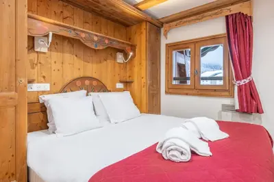 a bedroom with a white bed with a red blanket at Le Cristal - Central apartment close to the slopes & Free Parking - By Cozee Rentals in Chamonix-Mont-Blanc