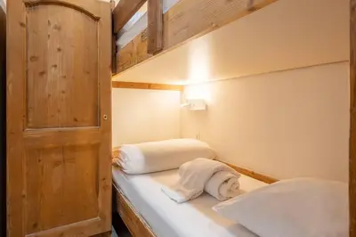 a small room with two bunk beds with towels at Le Cristal - Central apartment close to the slopes & Free Parking - By Cozee Rentals in Chamonix-Mont-Blanc