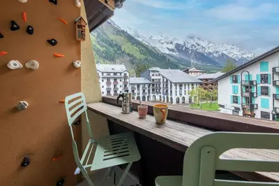 a balcony with a rock climbing wall and a chair at Lognan- New studio in the city center - By Cozee Rentals in Chamonix-Mont-Blanc