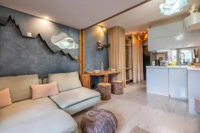 a living room with a couch and a kitchen at Lognan- New studio in the city center - By Cozee Rentals in Chamonix-Mont-Blanc