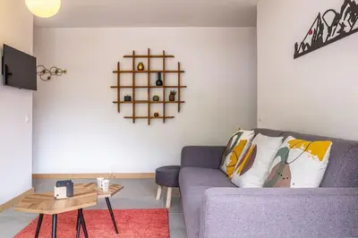 a living room with a purple couch and a table at Clos Savoy - New Apartment Close to City center & Free parking - By Cozee Rentals in Chamonix-Mont-Blanc