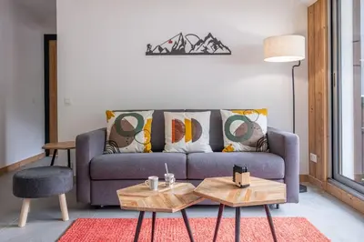 a living room with a couch and two tables at Clos Savoy - New Apartment Close to City center & Free parking - By Cozee Rentals in Chamonix-Mont-Blanc