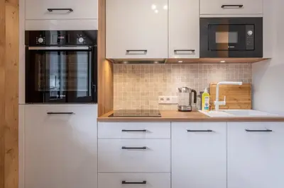 a white kitchen with a sink and a microwave at Clos Savoy - New Apartment Close to City center & Free parking - By Cozee Rentals in Chamonix-Mont-Blanc