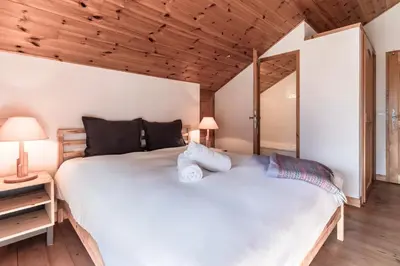 a bedroom with a large white bed and wooden ceilings at Appartement Edelweiss in Saint-Gervais-les-Bains