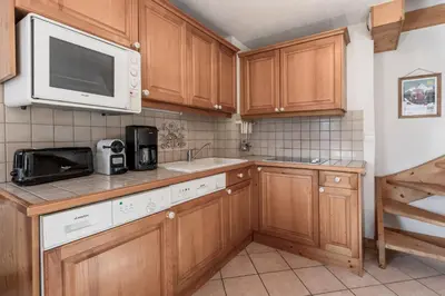 a kitchen with wooden cabinets and a microwave at Appartement Edelweiss in Saint-Gervais-les-Bains