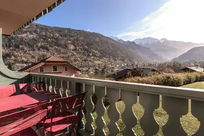 a balcony with red benches and a view of mountains at Appartement Edelweiss in Saint-Gervais-les-Bains