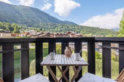 a table with cups and a vase on a balcony at Prarion - Modern apartment 4 pax Next to Ski lift - By Cozee Rentals in Les Houches