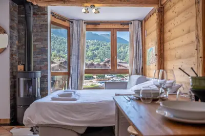 a bedroom with a bed and a large window at Prarion - Modern apartment 4 pax Next to Ski lift - By Cozee Rentals in Les Houches
