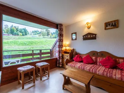 a bedroom with a bed and a large window at Les Eterlous - 8 - Appt Montagne 4-6 pers in Morillon