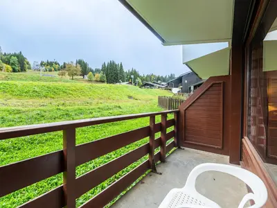 a kitchen with a table and chairs and a microwave at Les Eterlous - 8 - Appt Montagne 4-6 pers in Morillon