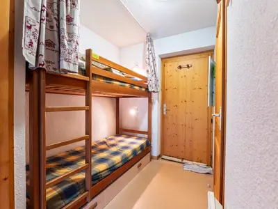 a bedroom with a red bed and a picture on the wall at Les Eterlous - 8 - Appt Montagne 4-6 pers in Morillon