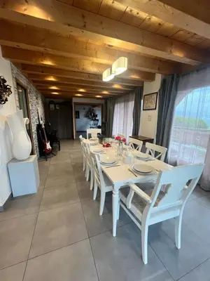a dining room with a white table and chairs at La Maison Magique! Magnifique chalet familial in Sallanches