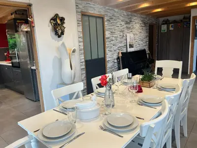 a white table with white chairs and plates on it at La Maison Magique! Magnifique chalet familial in Sallanches
