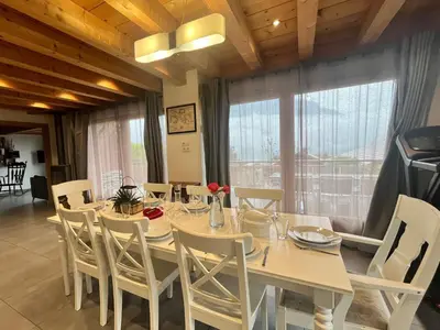 a dining room with a white table and chairs at La Maison Magique! Magnifique chalet familial in Sallanches