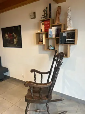 a wooden rocking chair sitting in a room at La Maison Magique! Magnifique chalet familial in Sallanches