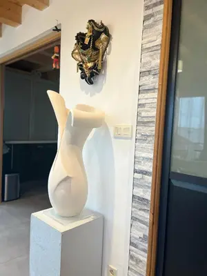 a white vase sitting on a stand next to a wall at La Maison Magique! Magnifique chalet familial in Sallanches