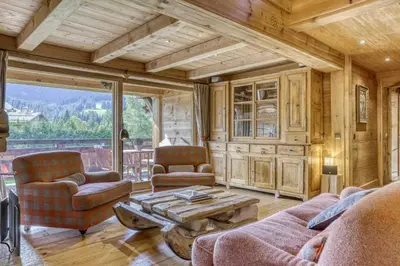 a living room with a couch and chairs and a table at Chalet Altitude in Megève