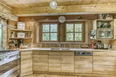 a kitchen with wooden cabinets and a sink and a stove at Chalet Altitude in Megève