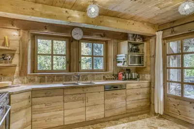a kitchen with wooden cabinets and a clock on the wall at Chalet Altitude in Megève