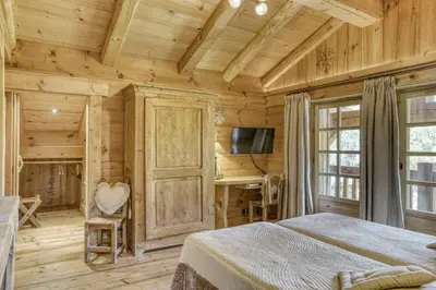 a bedroom with a bed and a desk and a television at Chalet Altitude in Megève