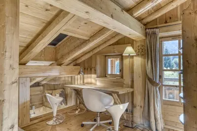 an office in a log cabin with a desk and chairs at Chalet Altitude in Megève
