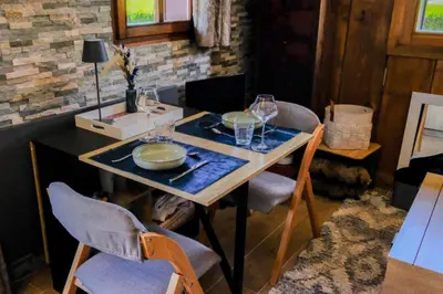 a table with chairs and glasses on top of it at Ali'Home vue MontBlanc - T2 de charme in Demi-Quartier