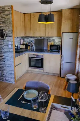 a kitchen with a table and a refrigerator at Ali'Home vue MontBlanc - T2 de charme in Demi-Quartier
