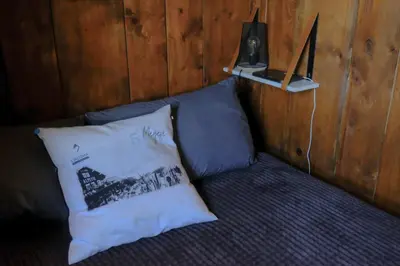 a couch with a pillow and a laptop on it at Ali'Home vue MontBlanc - T2 de charme in Demi-Quartier
