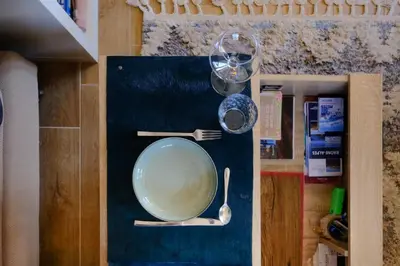 a bowl with a spoon and a glass on a table at Ali'Home vue MontBlanc - T2 de charme in Demi-Quartier